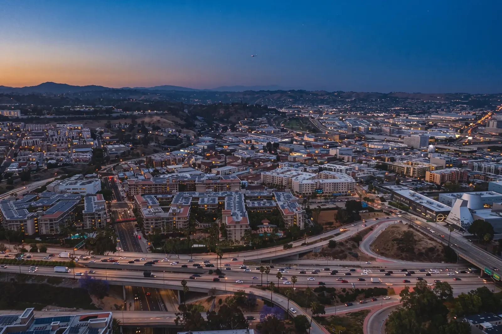 An aerial view of Southern California neighborhoods and freeways at dusk.